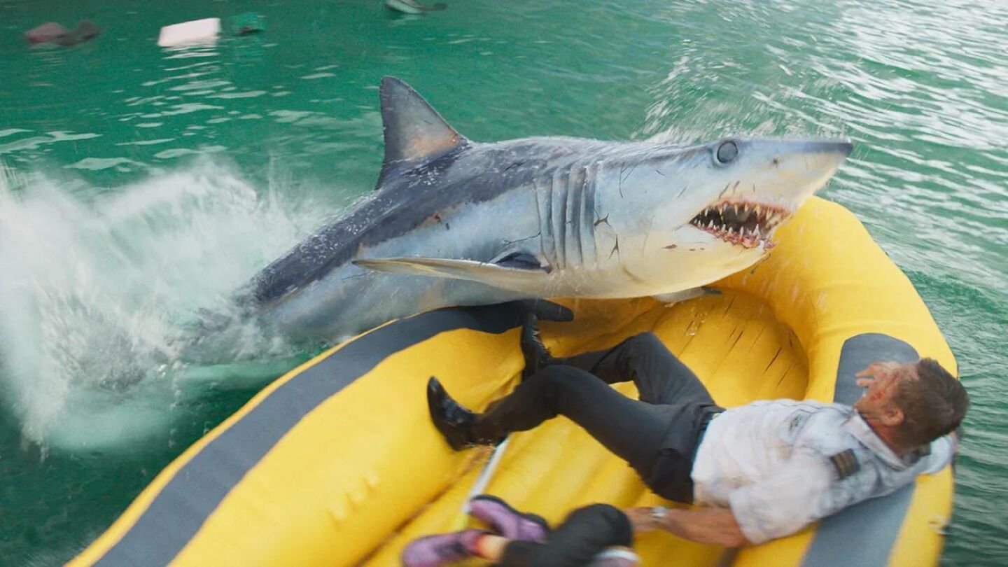 Escena de la película en la que el primer oficial del vuelo, interpretado por Aaron Eckhart, esquiva la mordida de un tiburón subido en un bote hinchable