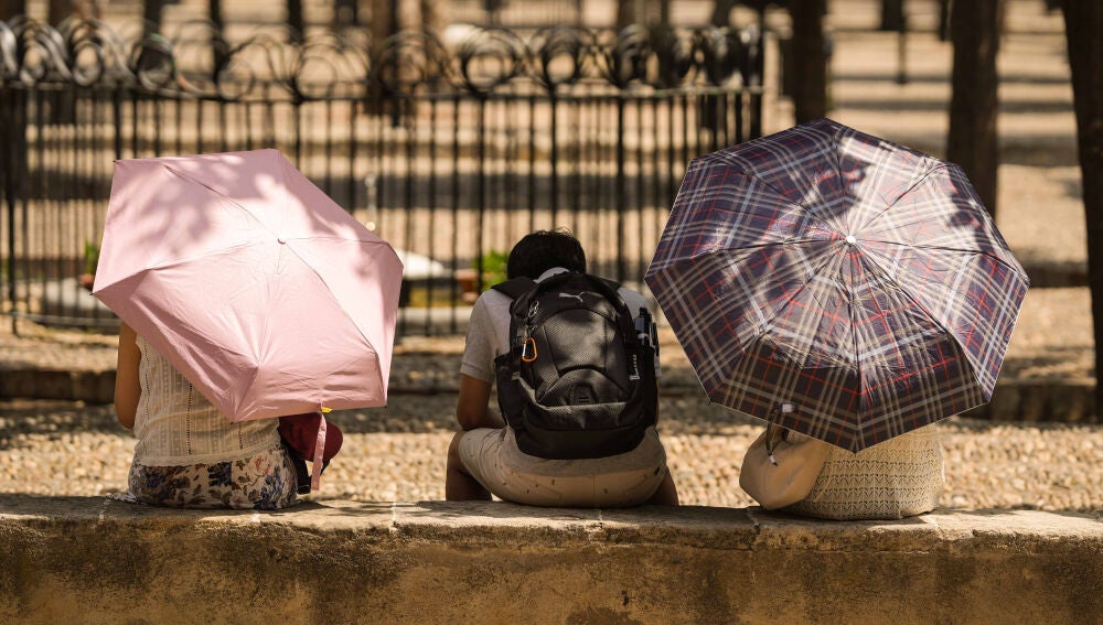 CÓRDOBA (ESPAÑA), 13/08/2026.- Unos turistas se protegen del sol en el Patio de Los Naranjos en Córdoba este jueves cuando el calor se intensifica en toda España, menos en Asturias, con temperaturas de 40 grados en la cuenca del Ebro, Andalucía, Extremadura y Castilla-La Mancha si bien se registrará