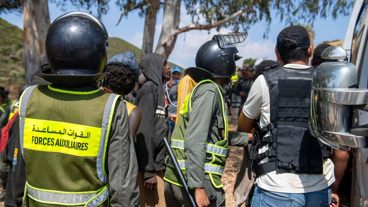Castillejos (Morocco), 15/08/2026.- Moroccan security forces arrest migrants as they prevent attempts by hundreds of sub-Saharan African and Sudanese migrants gathered near Fnideq (Castillejos), Morocco, to enter the Spanish city of Ceuta, 15 August 2026. Moroccan security sources said the attempted