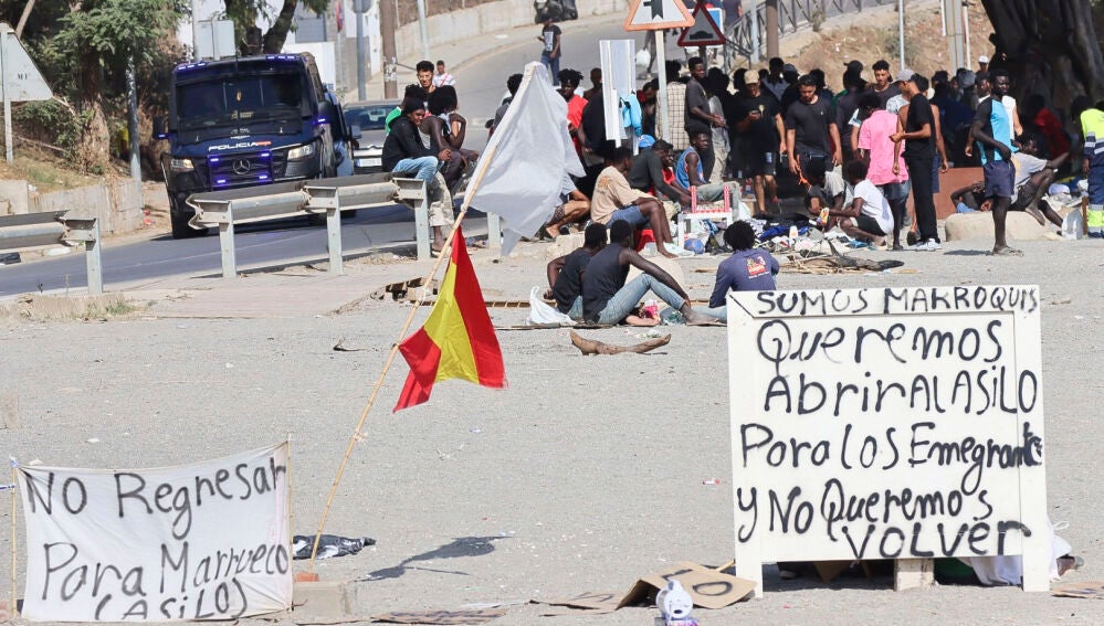 CEUTA, 18/08/2026.- Situación este martes en la playa del Trampolín de Ceuta. Más de un centenar de inmigrantes acampados en la playa del Trampolín, en Ceuta, tras atravesar la frontera de Marruecos el pasado 30 de julio iniciaron el lunes una huelga de hambre para pedir asilo en España y han asegur