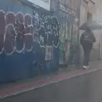 Una persona camina protegida por un paraguas.