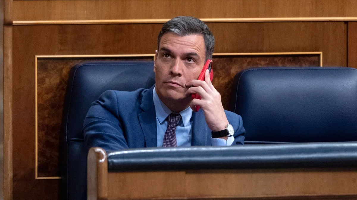 El presidente del Gobierno, Pedro Sánchez, habla por el teléfono, en una sesión extraordinaria en el Congreso de los Diputados