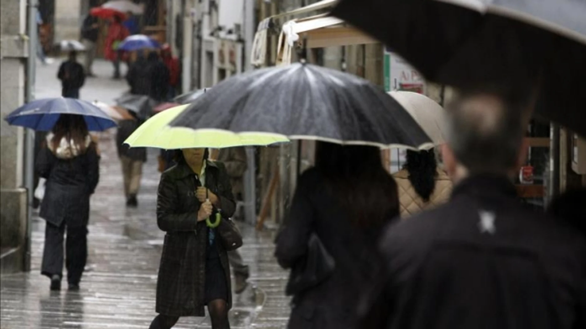 Varias personas se protegen de la lluvia con paraguas