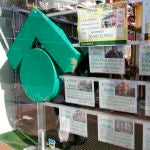 Numerosos carteles de venta de pisos ocupan el escaparate de una entidad inmobiliaria