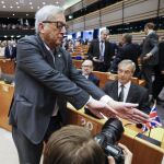 Juncker (i), intenta tapar la cámara a un fotógrafo que enfoca al líder del Partido de la Independencia de Reino Unido (UKIP), Nigel Farage (d)