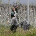 Un Policía apunta con su arma a un refugiado en la frontera de Idomeni
