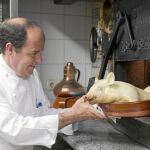 Cándido López se dispone a colocar un cochinillo en el horno
