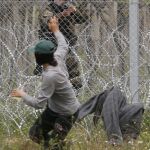 Un hombre intenta defenderse de la Policía de fronteras en Idomeni, ayer
