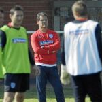 Capello, al fondo, pensativo durante un entrenamiento