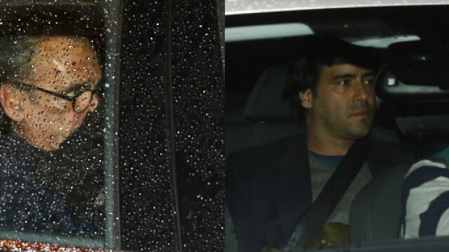 Mario Conde (izda.) y su hijo (dcha.) salen anoche de su vivienda de Madrid junto a la Guardia Civil, tras finalizar el registro