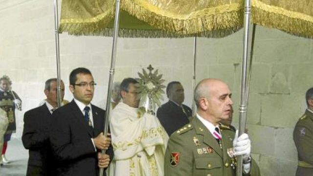 Autoridades civiles y militares portan el palio bajo el que procesionó el Corpus en el interior del Monasterio de las Huelgas de Burgos