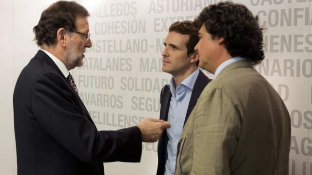 Mariano Rajoy conversa con el que será vicesecretario de Comunicación, Pablo Casado (2d), y el futuro director de campaña para las elecciones generales, Jorge Moragas.