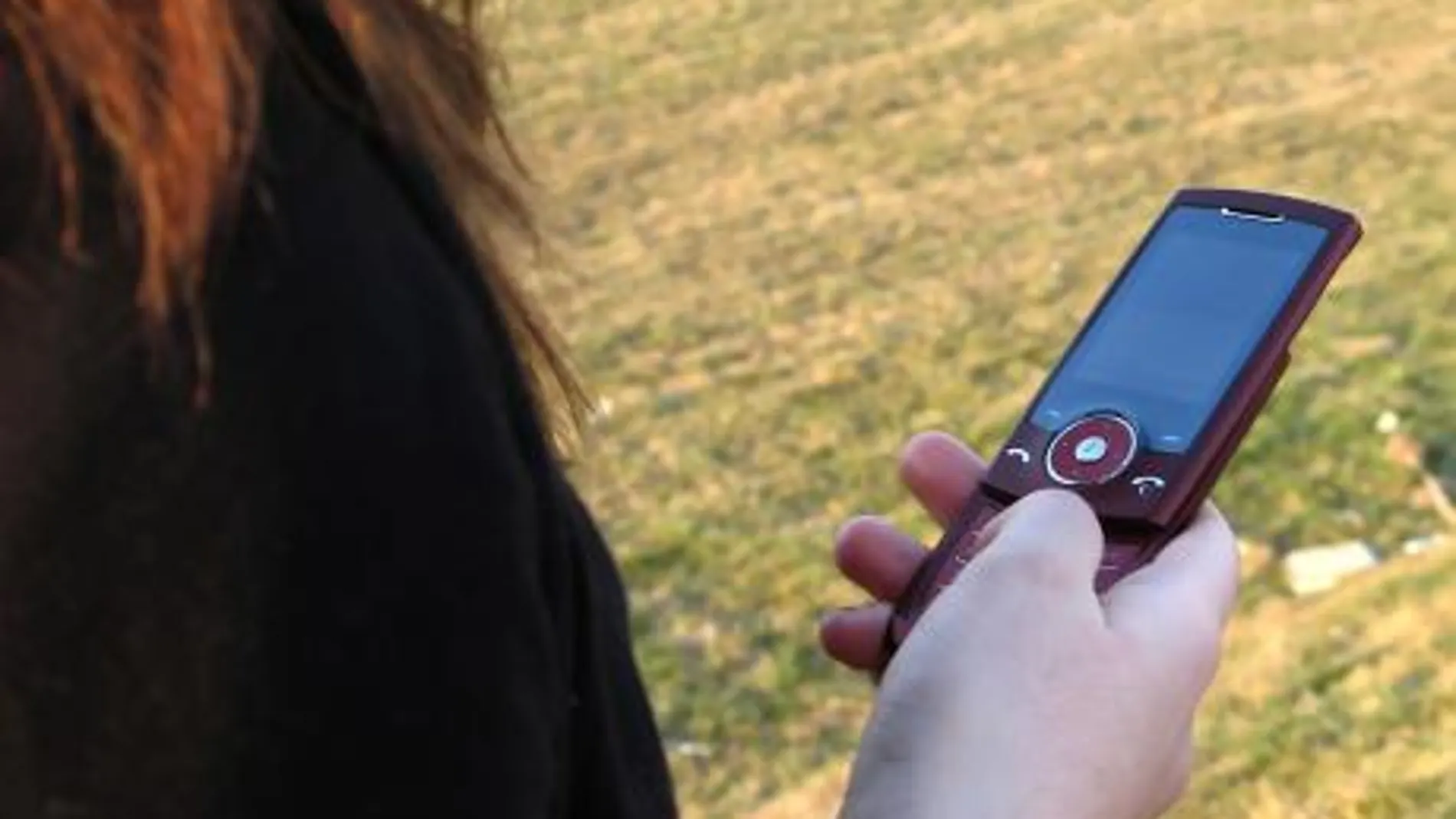 Una mujer utiliza un teléfono móvil para hacer una llamada