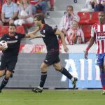 Carlos Gurpegui (i), celebra su gol, el primero de su equipo, junto a su compañero delantero, Fernando Llorente (c), en presencia del defensa francés del Sporting de Gijón, Gregory Arnolin