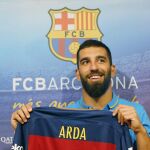 El centrocampista turco Arda Turan, posa con su camiseta durante su presentación