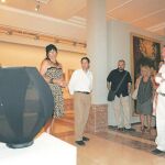La artista belga, Monique Bastiaans, enseña y comenta con sus admiradores una de sus obras