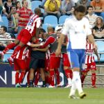 Los jugadores del Sporting de Gijón (al fondo) celebran su segundo gol, materializado por el delantero Diego Castro