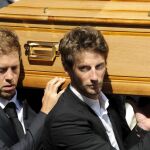 El piloto alemán de Fórmula Uno Sebastian Vettel (i) y el francés Romain Grosjean portan a hombros el féretro de Bianchi