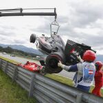 El monoplaza de Fernando Alonso es retirado de la pista tras el accidente sufrido con Raikkonen