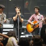 Nick Jonas en un concierto junto a sus hermanos