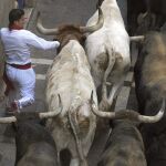 Un mozo corre ante los toros de la ganadería de Miura