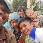Proctor con unos niños vietnamitas durante su vuelta a unas tierras que pisó hace cuarenta años de una manera muy diferente