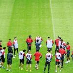 Quique habla con sus futbolistas sobre el césped durante una sesión de trabajo del Atlético de Madrid