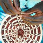 Una mujer africana elabora una cesta a mano