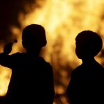En la imagen, dos niños frente a las hogueras de las fiestas de San Juan | Imagen de archivo
