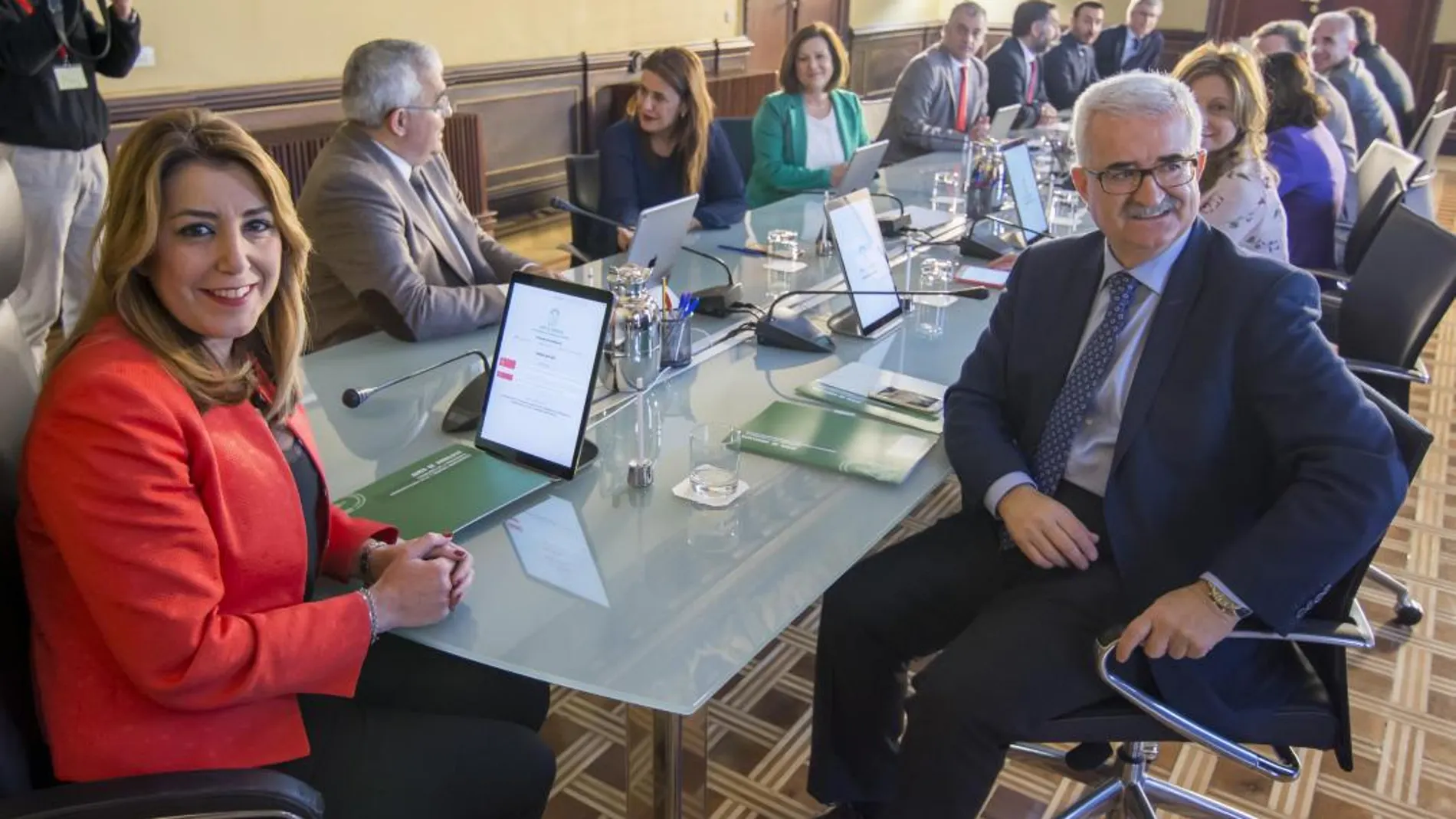 La presidenta de la Junta de Andalucía, Susana Díaz (i), al comienzo de la reunión extraordinaria del Consejo de Gobierno en el Palacio de San Telmo en Sevilla, en la que se aprobaron los decretos correspondientes de concesión de títulos honoríficos y Medallas de Andalucía con motivo del Día de la Comunidad