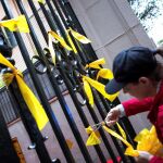 Una joven retira de los Grupos de Defensa y Resistencia (GDR), contrarios a la independencia de Cataluña, retirando lazos amarillos