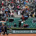 El tenista español David Ferrer (2i) sale de la pista tras suspenderse ayer su partido frente al checo Tomas Berdych