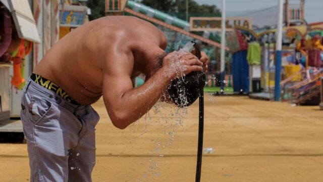 Un hombre se refresca en el recinto ferial de Huelva, donde hoy se han registrado 45 grados de máxima. /Foto: Efe