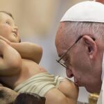 El Papa Francisco besa una figura del niño Jesús antes de presidir la Santa Misa
