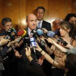 El ministro de Economía en funciones, Luis de Guindos (c) acompañado del presidente del grupo parlamentario del PPC, Xavier García Albiol (d)