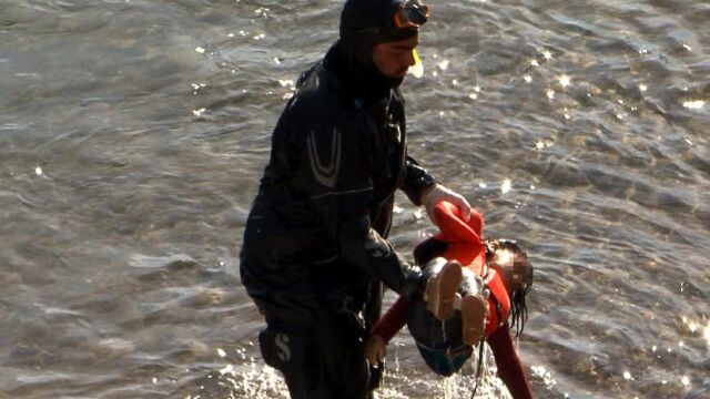 Un miembro de la Guardia Costera saca del agua el cuerpo de una niña en la costa de la isla de Lesbos