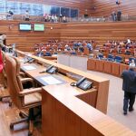 La presidenta del legislativo, Silvia Clemente, accede a la mesa de las Cortes, con los procuradores infantiles al fondo