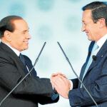 Berlusconi y Fini se dan las manos durante la segunda jornada del congreso del PdL, ayer en Roma