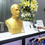 Un empleado registra su entrada ante la férrea mirada del busto de Jobs
