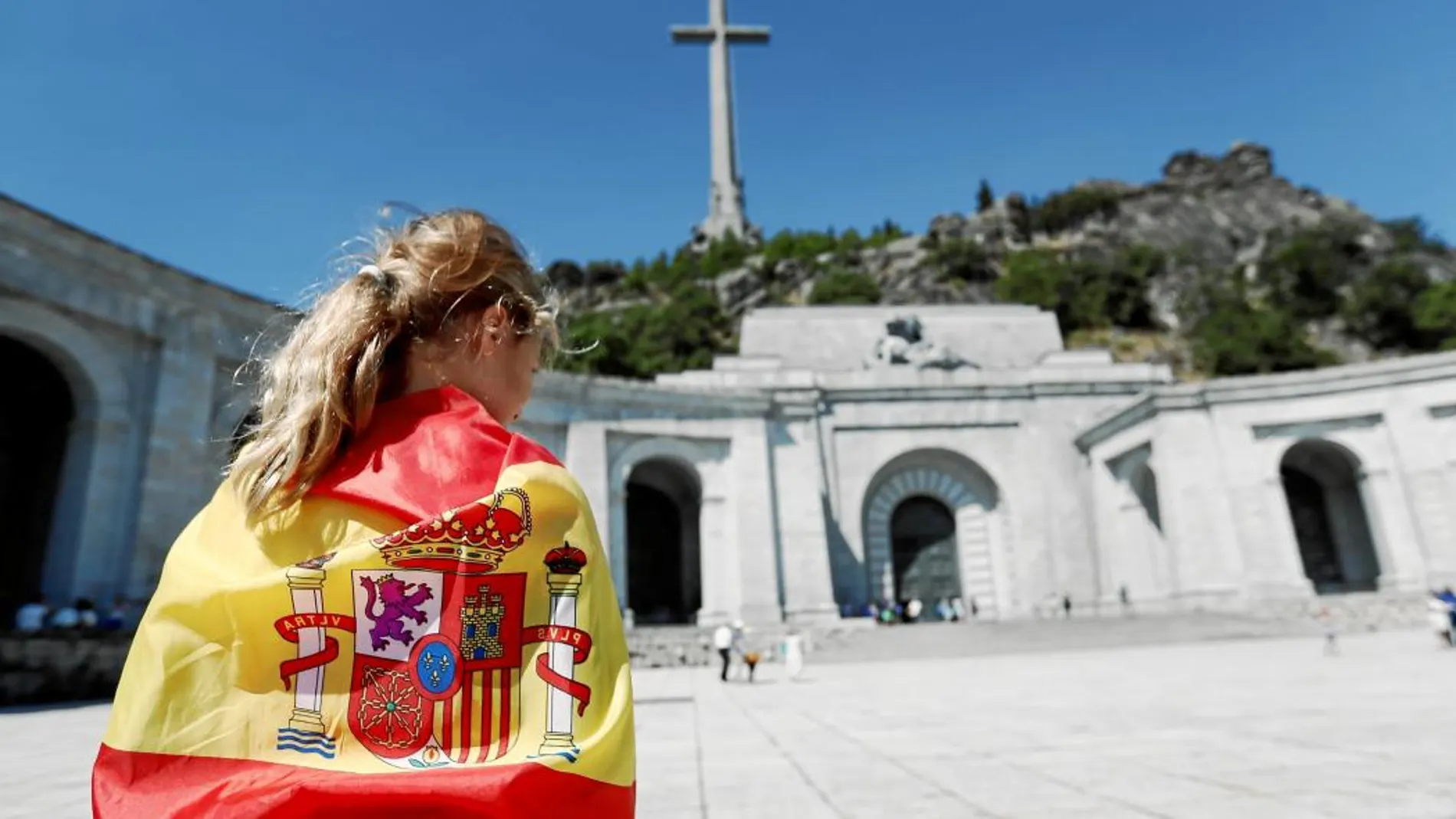 Una joven envuelta en la bandera, en la explanada de la Basílica del Valle de los Caídos, rebautizado como Cuelgamuros