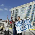 Un grupo de personas sostiene una pancarta y agita banderas frente a la embajada de Estados Unidos en La Habana (Cuba). Lunes 20 de julio del 2015.