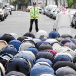 Un grupo de musulmanes reza en una calle de Londres ante la antenta mirada de un policía