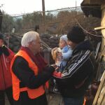 Entrañable imagen, el Padre Ángel, en el centro, ofreciendo alimento a un bebé turco en brazos de su padre, a la izda., la madre del niño.