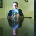 Daniel portero, presidente de Dignidad y Justicia, con un libro con la foto de su padre, el fiscal Luis Portero, asesinado por ETA