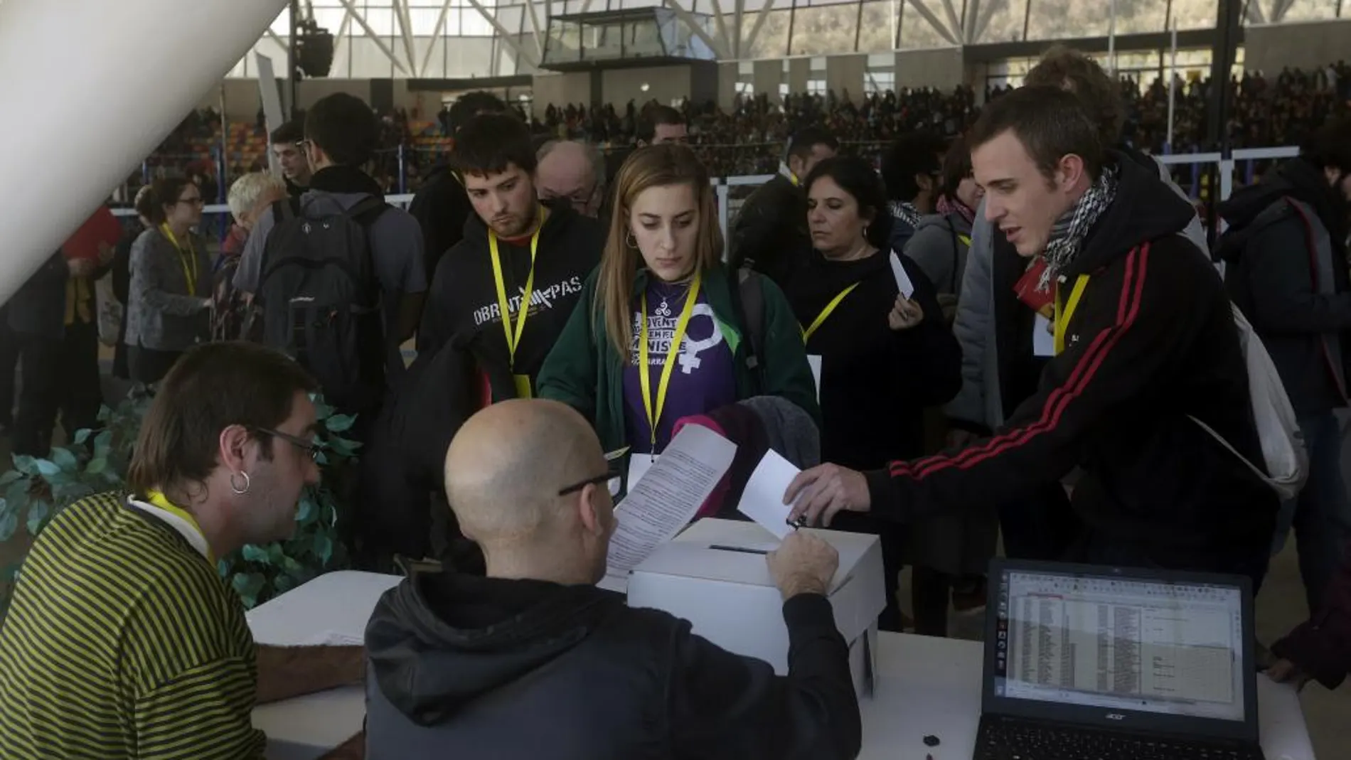 Los participantes en la primera votación realizada durante la asamblea de la CUP sobre la investidura de Artur Mas como presidente de la Generalitat