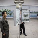 Norcoreanos leen periódicos en el metro durante una visita organizada de periodistas extranjeros a Pyongyang para la celebración del 70 aniversario del Partido de los Trabajadores
