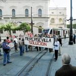 Los manifestantes despliegan una pancarta al paso del tranvía