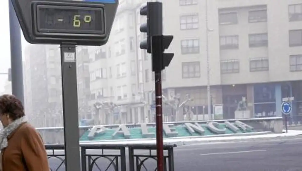 Una mujer huye del frío en la fuente en la que está impreso el nombre de Palencia