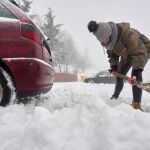 Una joven retira la nieve acumulada tras la nevada copiosa caída de madrugada en Galicia. EFE/EliseoTrigo