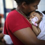 Una madre junto a un niño afectado por el virus.